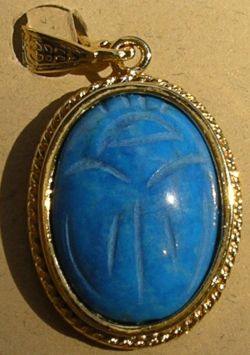 Turquoise-colored carved scarab stone in vermeil setting.